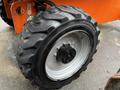 Close-up of a rugged tire on a 2012 JLG 660SJ with a thick tread pattern and a metallic rim