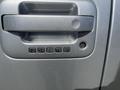 Close-up of the door handle of a 2014 Ford F-150 featuring a keypad with numbers 1 through 9 for keyless entry
