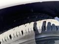 A close-up view of a worn tire from a 2014 Chevrolet Express showing visible tread wear and cracks in the rubber