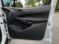 The interior driver's side door of a 2016 Ford Transit Connect featuring a black door panel with a handle speaker and storage compartment
