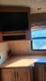 A 2007 Winnebago Adventure interior featuring wooden cabinets a countertop and an empty space for a television