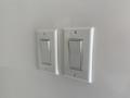 Two white light switches mounted on a wall