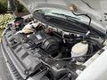 A 2020 Chevrolet Express with the hood open showcasing the engine compartment and various mechanical components including hoses and fluid reservoirs