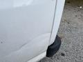 A 2014 GMC Savana with a noticeable dent on the side panel and minor dirt marks near the wheel area