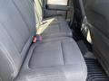 The image shows the back seat area of a 2014 Ford F-150 with gray fabric upholstery and a flat surface floor mat