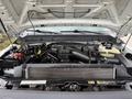 Engine compartment of a 2015 Ford F-350 SD showing various engine components including the air intake manifold radiator and various hoses and wiring