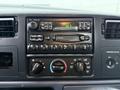 Interior dashboard of a 2001 Ford F-350 featuring audio controls a digital clock and climate control knobs