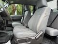 Interior view of a 2015 Ford F-350 SD showing front seats with gray upholstery and a black floor mat