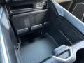 Interior console storage space of a 2022 RAM 3500 featuring textured surfaces and electrical outlets