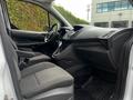 Interior view of a 2014 Ford Transit Connect showing the front seats dashboard and center console with grey upholstery and controls