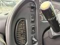 Close-up of the control panel inside a 2014 Freightliner B2 featuring multiple buttons including those for speed and cruise control along with a gear shift knob