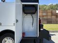 A 2023 Ford F-550 with an open compartment showing a black tank and connected hose inside