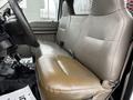 A tan leather bench seat inside a 2008 Ford F-450 SD truck with a simple design and minimal controls visible in the foreground