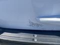 A white 2013 Ford Expedition with visible paint damage on the rear side and scratches on the bumper