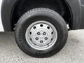 A close-up view of a silver wheel with a RAM logo and black tire on a 2021 RAM Promaster