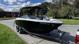 A 2023 Mercury Monterey boat on a trailer with a sleek black hull and a pointed bow