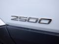 Close-up of a silver emblem displaying the number 2500 on a white 2016 Mercedes-Benz Sprinter van