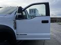 A 2017 Ford F-550 truck with a white exterior and a partially open driver's side door showing the handle and mirror