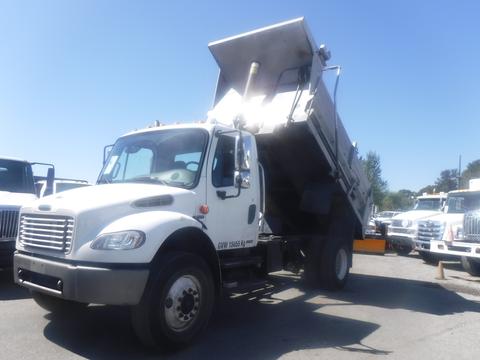 A white 2005 Freightliner M2 106 Medium Duty dump truck with a raised bed and visible hydraulic lift system