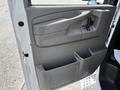 Interior door panel of a 2013 Chevrolet Express featuring a handle storage compartment and cup holders