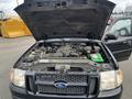 A 2004 Ford Explorer Sport Trac with its hood raised showcasing the engine and battery compartment