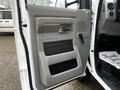 Interior door panel of a 2017 Ford Econoline featuring a smooth gray finish with a handle and speaker grill