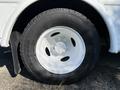 Close-up of a white wheel and tire from a 2021 Ford Econoline showing the tire tread and rim design