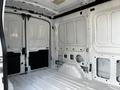 A 2021 Ford Transit van with its rear doors open revealing an empty cargo area featuring smooth white walls and a flat floor
