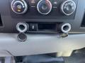 The dashboard of a 2013 Chevrolet Silverado 1500 featuring climate control knobs and two circular openings with caps for charging ports