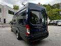A dark blue 2017 Ford Transit 350 van viewed from the rear showcasing its large back doors and rounded shape