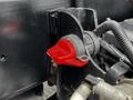 Close-up of a red valve handle on the engine of a 2017 International WorkStar 7600 with surrounding black engine components