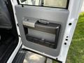 The interior door panel of a 2016 Ford F-550 featuring a metallic handle and a storage compartment with multiple dividers