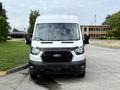 A white 2022 Ford Transit van facing directly towards the viewer with a black grille and prominent headlights