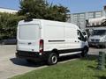 White 2022 Ford Transit van with a sliding side door parked in an outdoor area