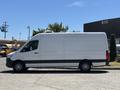 A 2019 Mercedes-Benz Sprinter van in white with a streamlined design and black accents viewed from the side