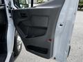 The interior side of the driver door of a 2022 Ford Transit showing the handle and storage compartment