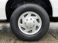 Close-up of a silver alloy wheel and tire from a 2013 Ford E-350 showing five spokes and tread pattern