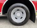 A close-up view of a tire from a 2007 Ford F-550 with an all-black tread and silver wheel rim featuring multiple bolts
