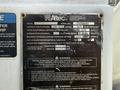 A metal identification plate detailing specifications and warnings for a 2011 International 4300 vehicle including capacity platform and maximum hydraulic system pressure