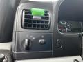 Dashboard controls and air vent of a 2007 Ford F-550 with a green object on the air vent and a speedometer visible in the background