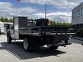 A 2016 Ford F-550 flatbed truck with a black cargo area and tool storage compartment in the back