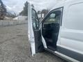 A 2024 Ford Transit van with the driver's side door open showcasing the interior and dashboard