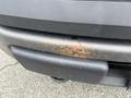 Close-up of a rusted bumper on a 2010 Ford F-150 showing visible corrosion and deterioration on the metal surface