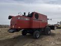 A red 1997 Massey Ferguson 8680 combine harvester with large tires and a hopper attached to the side