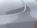 A close-up of a silver 2018 Ford Transit van with water droplets on its surface