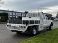 A white 2014 Ford F-250 SD truck with a utility bed featuring multiple storage compartments and a metal grid on the rear