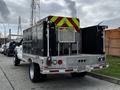 A 2007 Ford F-550 truck with a flatbed and tool storage boxes on the back