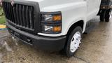 Front view of a 2021 International CV515 truck showing the grille headlights and front wheel with a wet surface below