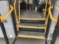 The entrance of a 2016 Chevrolet Express showing yellow steps and handrails leading into the interior of the vehicle