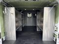 Interior of a 2023 Ford Transit van featuring metallic shelving units on both sides designed for storage and organization